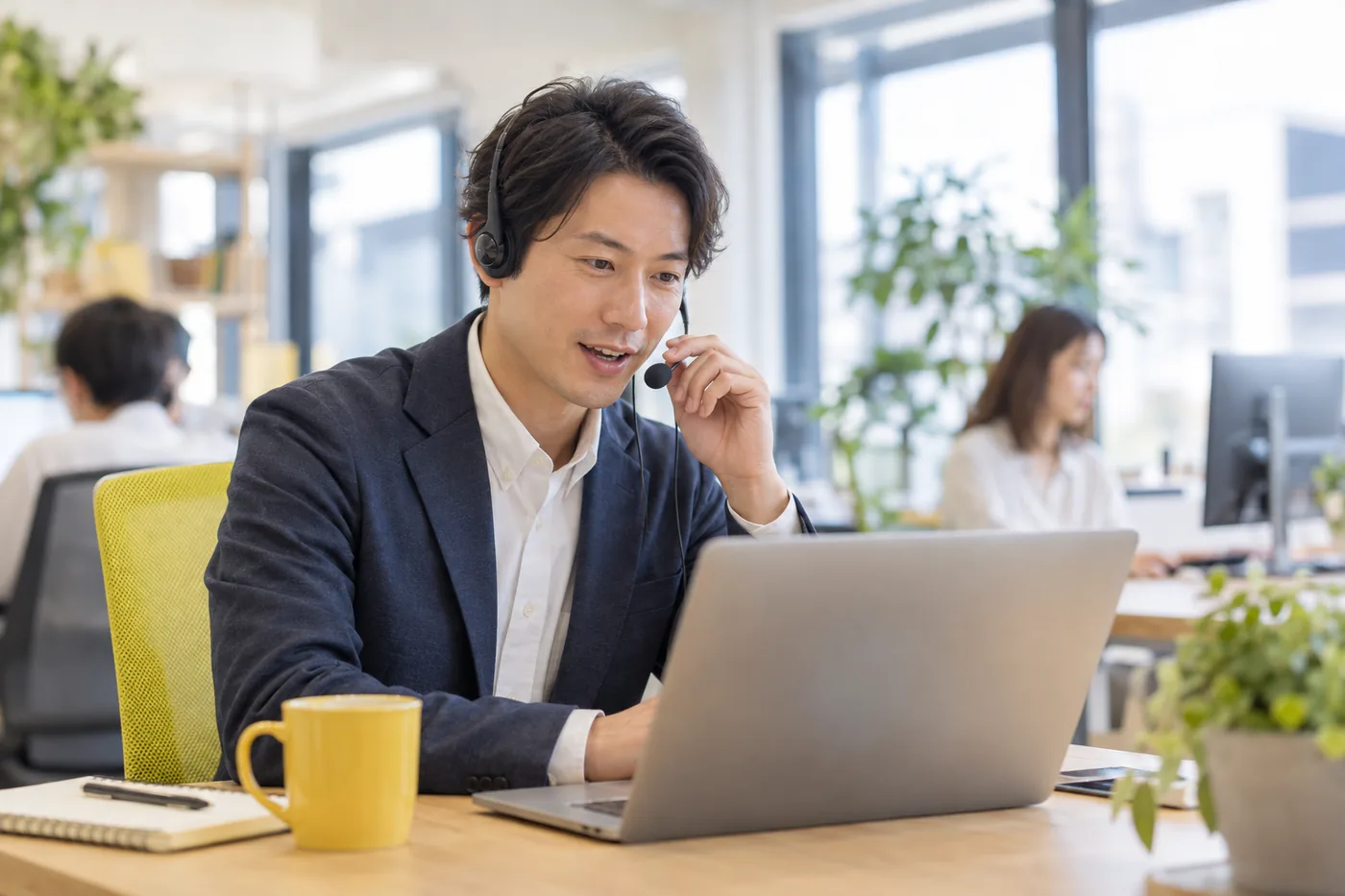 ヘッドセットをつけて電話に出る男性