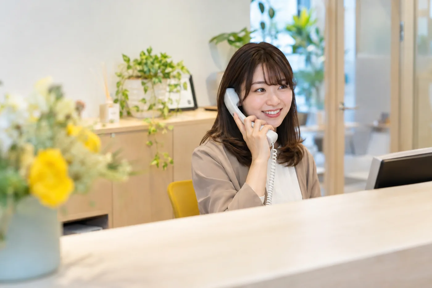 会社の受付で電話に出る女性